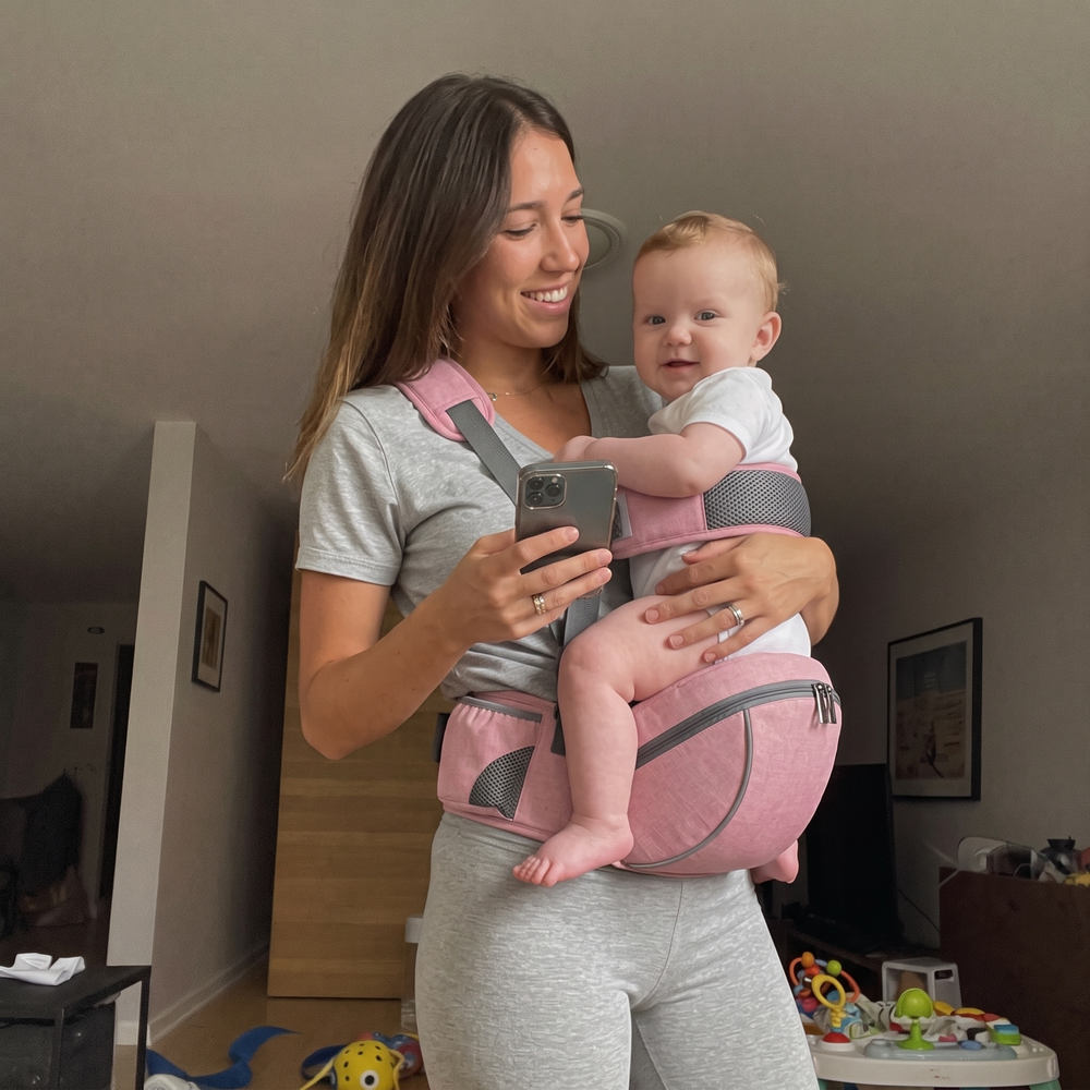 Mom carrying baby with the NestSeat hip carrier